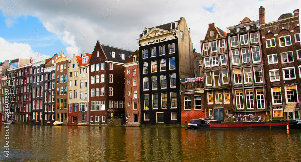 View of the unique architecture and gabled homes and coffee shop along a colorful canal