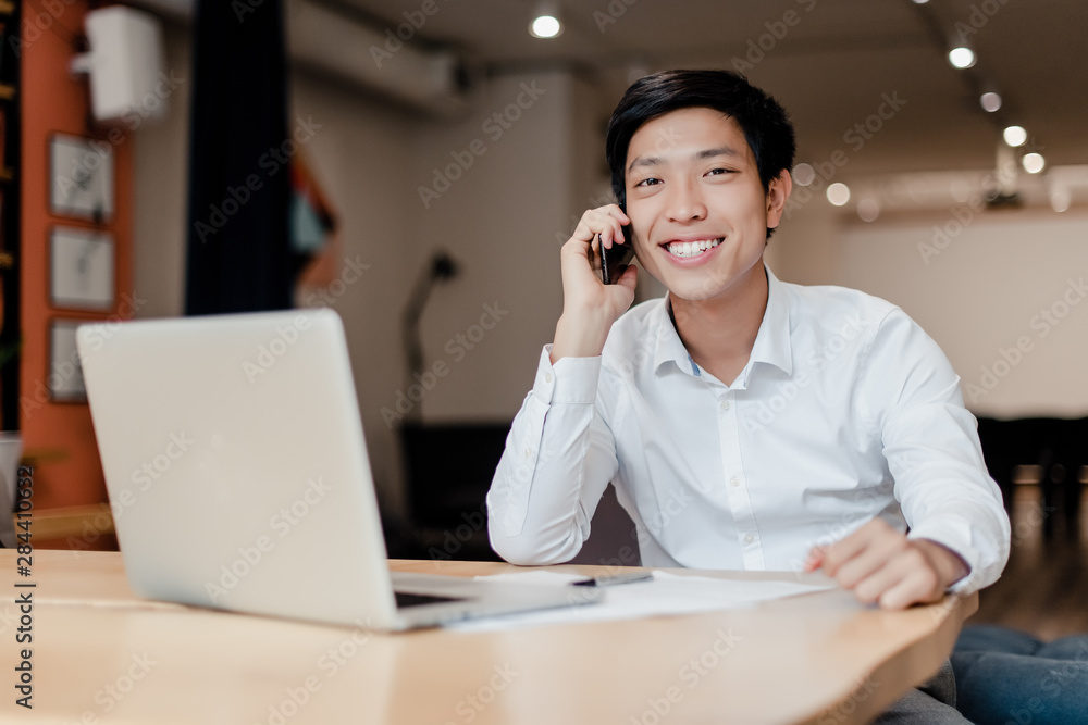 smiling asian businessman talking on the phone
