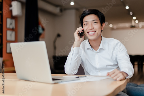 smiling asian businessman talking on the phone