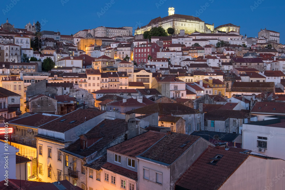 Portugal, Coimbra. Hillside view of houses and the University of Coimbra neighborhood, at sunset into the evening.