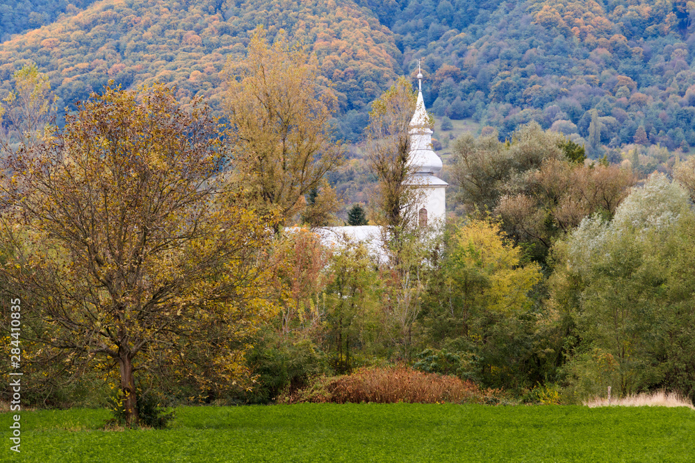 Romania. Maramures County. Baia Mare. Church near Firiza. Lake Firiza. Fall color.