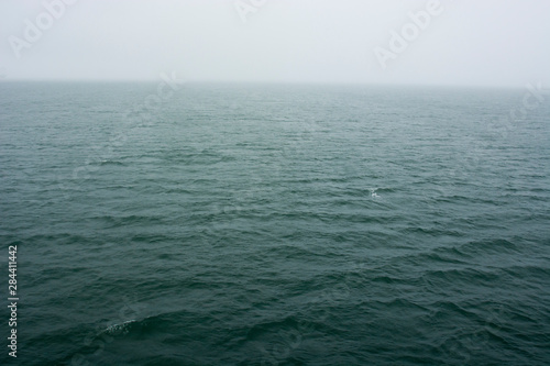 Norway. Svalbard. Hornsund. Heavy clouds over the calm water.