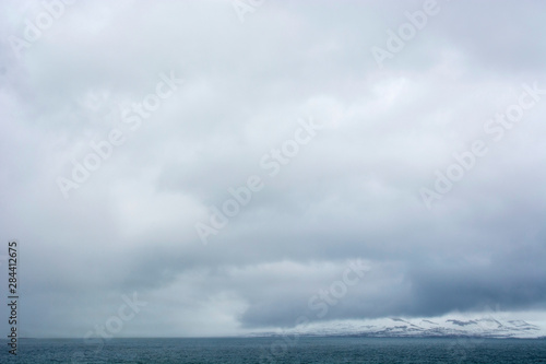 Norway. Svalbard. Hornsund. Heavy clouds over the calm water.