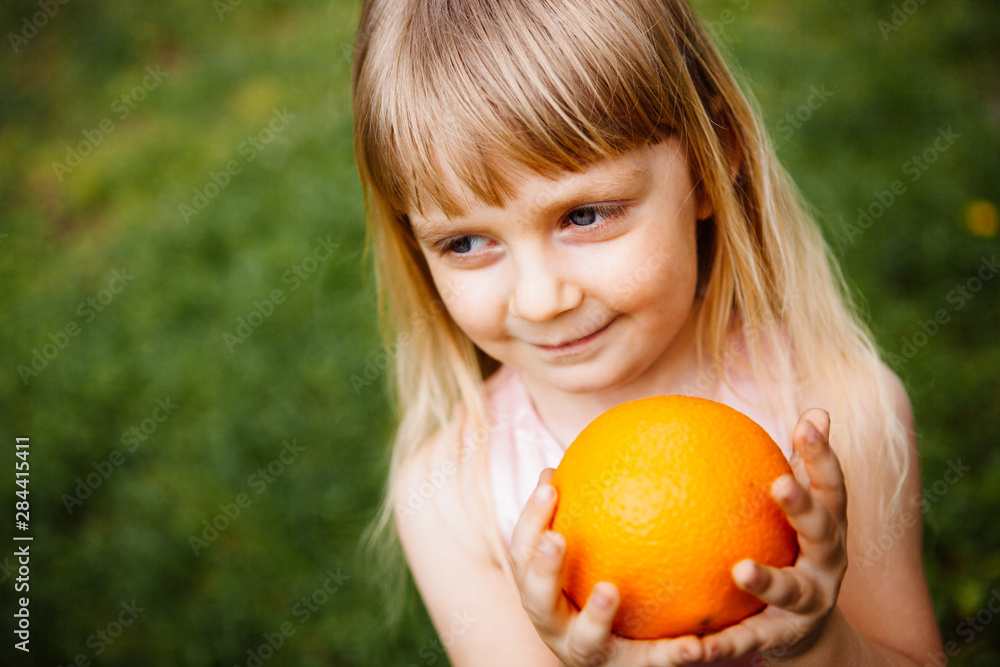 Little girl smile with orange fruit in hands, healthy lifestyle and diet Little girl smile with orange fruit in hands, healthy lifestyle and diet