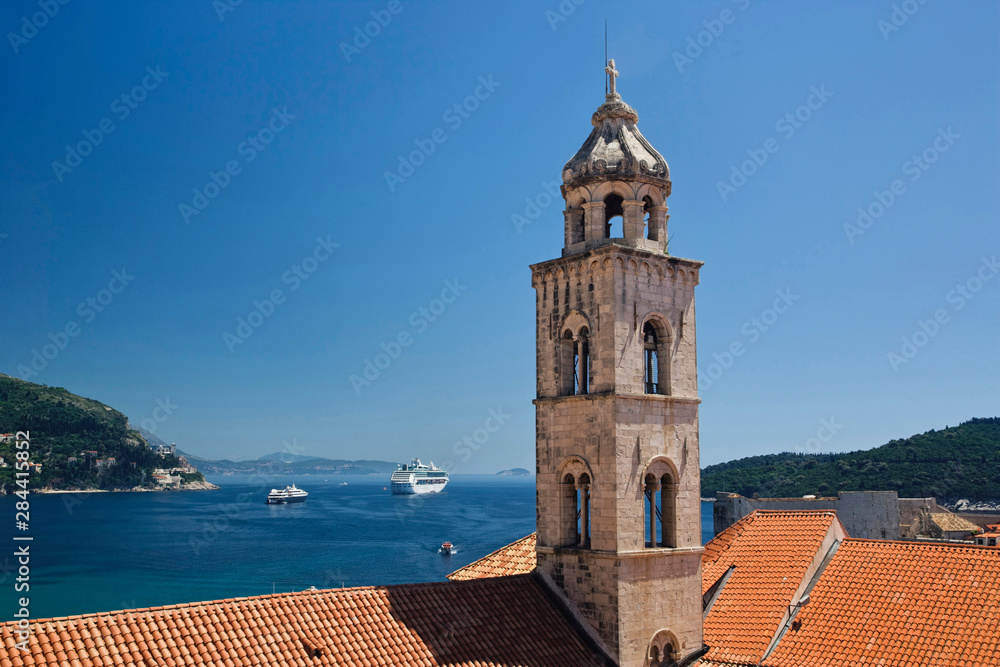 Church bell tower and cruise ship docked in the Adriatic Sea at historic Dubrovnik, Croatia a UNESCO World Heritage Site