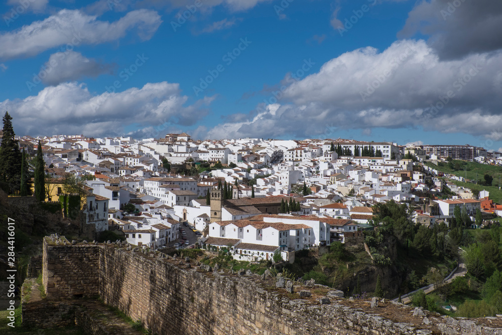 Spain, Andalusia, Ronda. Ronda is a classic example of a whitewashed hilltop village along the White Road, viewed here with the ruins of the old Roman stone wall of the city.