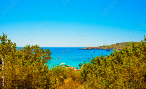  blue sea with clear water, mountains, yachts and the beach on the panorama of Konnos Bay Cyprus
