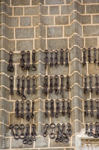 Spain  Castilla-La Mancha Toledo. Chains hanging on exterior wall of historic church.