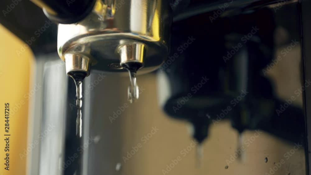 Water pours through the portofilter of the coffee machine. Professional