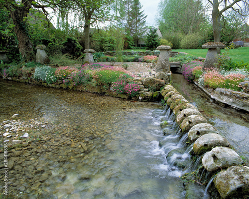 England, Teffont Magna. A stream flows beside a garden in Teffont Magna in Wiltshire, in southern England. photo