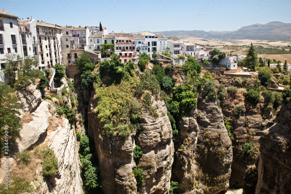 Spain, Andalusia, Malaga Province, Ronda. A view of the white hillside town of Ronda over the valley cliffs dividing the new town from the old.