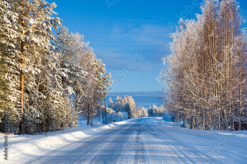 Snow covered road, near Lulea, Northern Sweden photo