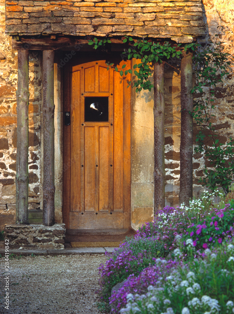 England, Chippenham. An old wooden door welcomes visitors to a thatched-roofed cottage in Chippenham, Wiltshire, England. England, Chippenham. An old wooden door welcomes visitors to a thatched-roofed cottage in Chippenham, Wiltshire, England.