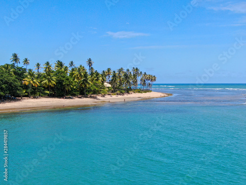 Foto Aerial view of tropical white sand beach, palm trees  and turquoise clear sea water in Praia do Forte, Bahia, Brazil