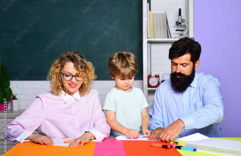 Happy school kids at lesson in September 1. Family education. Family school. Beginning of lessons. Cheerful family playing with set for creativity. Child from elementary school with parents in school. Happy school kids at lesson in September 1. Family education. Family school. Beginning of lessons. Cheerful family playing with set for creativity. Child from elementary school with parents in school.