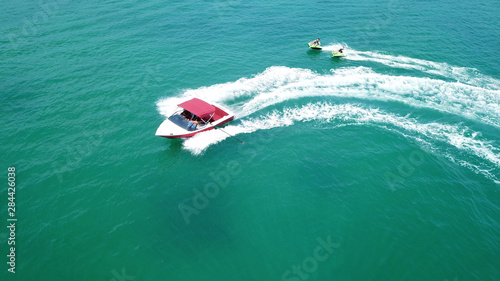 Aerial drone photo of extreme powerboat donut watersports crusing in high speed in tropical turquoise bay