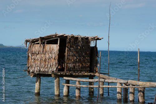 Melanesia, Papua New Guinea, Dobu Island. Typical island village over water outhouse. photo