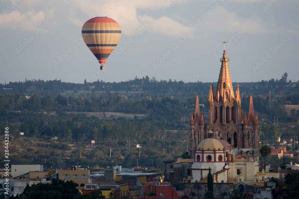 Fototapeta premium Mexico, San Miguel de Allende. Hot air balloon drifting past La Parroquia Cathedral.