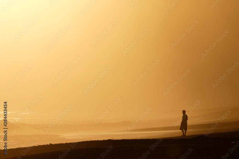 Costa Rica, Osa Peninsula. A surfer studies the waves at sunset along the Osa Peninsula. 