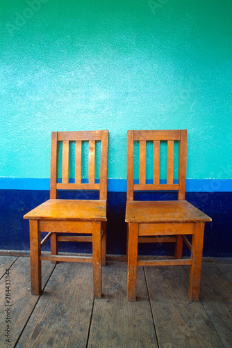 Central America, Guatemala. Two wooden chairs against blue wall. Credit as: Jim Nilsen / Jaynes Gallery / DanitaDelimont.com photo