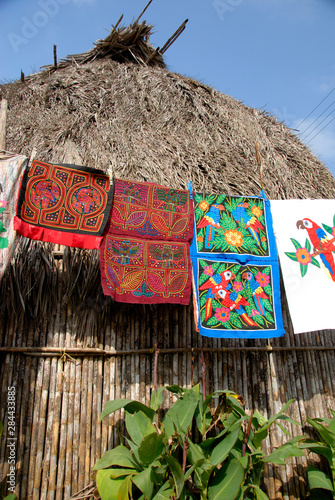 Central America, Panama, San Blas Islands (aka Kuna Yala). Colorful hand stitched molas made by the Kuna Indians hanging in front of typical Kuna home.