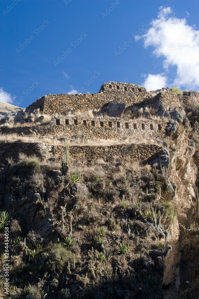 Fototapeta premium South America - Peru. Small portion of Inca fortress on hill overlooking village of Ollantaytambo in Sacred Valley of the Incas.
