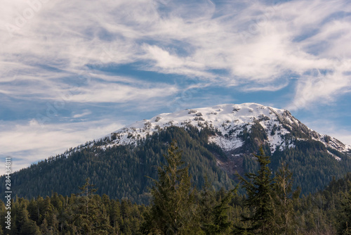 US, Alaska, Ketchikan. Snow capped mountain of Coast Range in Tongass National Forest seen from Ward Lake Trail
