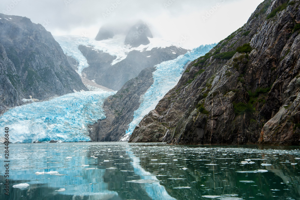 The terminus of a glacier is reflected in the green water of Resurrection Bay