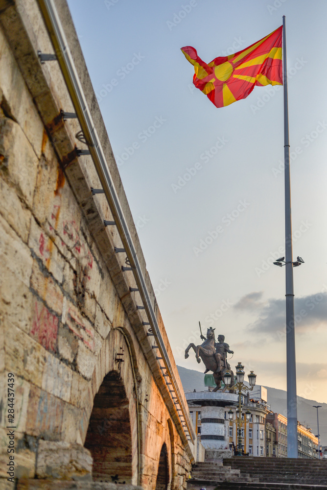 Skopje,Stone Bridge, with Macedonian flag and statue of warrior on horse.