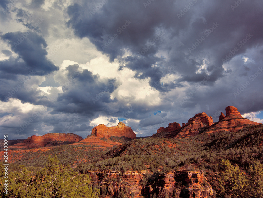 Fototapeta premium USA, Arizona, Oak Creek Canyon. An early spring storm passes over the red rock monoliths of Oak Creek Canyon, near Sedona, in Arizona.