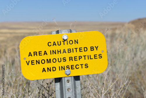 USA, Arizona, caution area inhabited by venomous reptiles and insects sign, Homolovi State Park photo