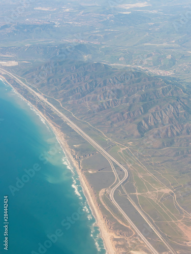 Usa, California. Aerial of undeveloped coastline Camp Pendleton. Cars backed up from Border Patrol Inspection station on Interstate 5