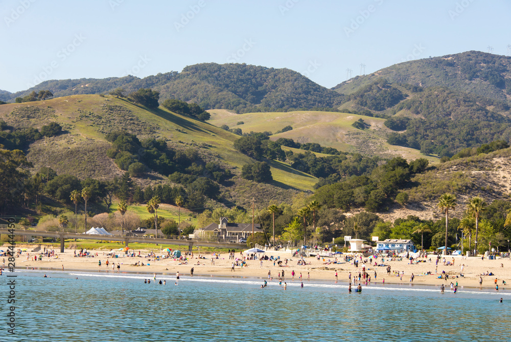 USA, California, Avila Beach. Coastal mountains backdrop for warm spring day beach goers.