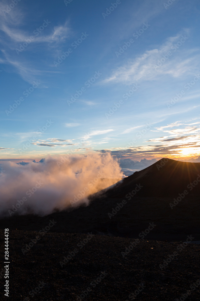 Obraz premium Sunset viewed from the top of Mauna Kea Volcano on the Big Island of Hawaii with lava rock in foreground