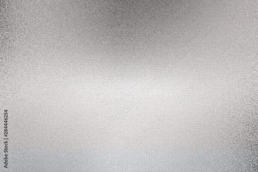 Glowing silver foil metallic sheet with scratched surface, abstract texture background Glowing silver foil metallic sheet with scratched surface, abstract texture background