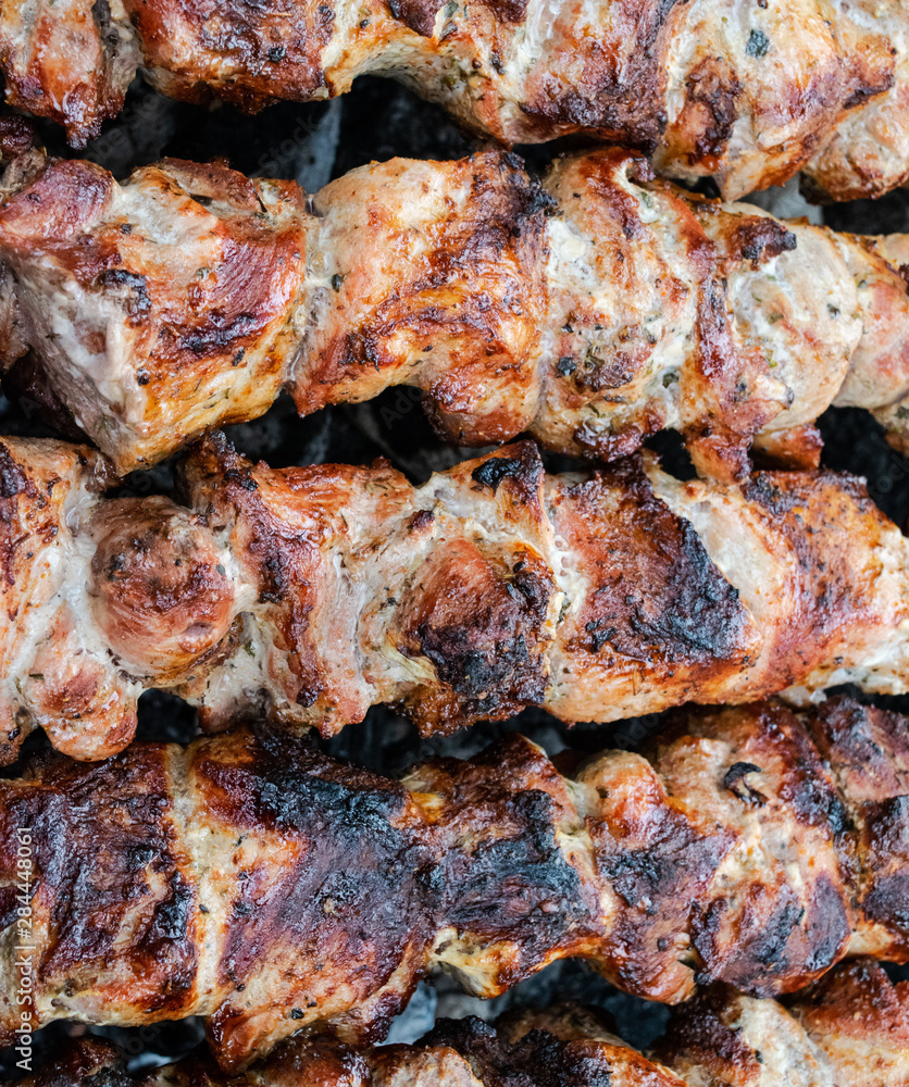 Frying pork on a skewer over a brazier. Turning meat over coals. Appetizing shish kebab. Frying pork on a skewer over a brazier. Turning meat over coals. Appetizing shish kebab.