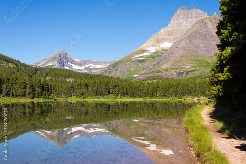 US, MT, Glacier National Park. Glass calm on Fishercap Lake in the Many Glacier area. Accessed from Swift current campground photo
