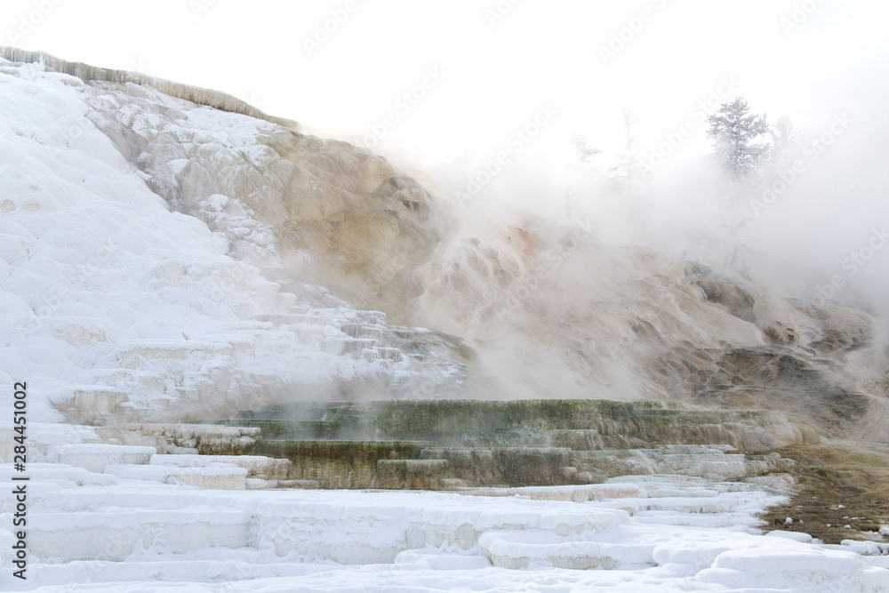 Yellowstone National Park, WY, USA. Steam rises from a shallow area at Mamoth Hot Springs causing frost to form just above the water's surface. Yellowstone National Park, WY, USA. Steam rises from a shallow area at Mamoth Hot Springs causing frost to form just above the water's surface.