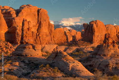 USA, Utah. Red rock formations and snow on the La Sal Mountains at sunset