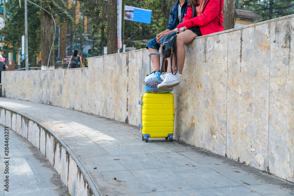 Yellow suitcase of traveler sit on roadside. Travel concept Yellow suitcase of traveler sit on roadside. Travel concept