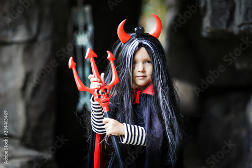 Little Girl with a demon devil costume. Halloween concept