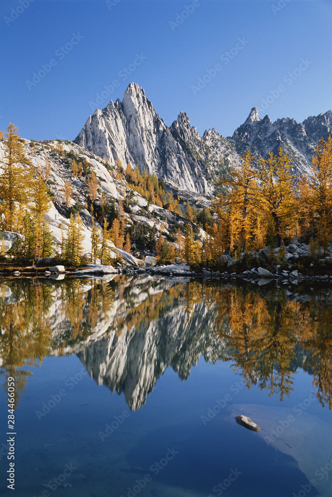 Prusik peak and larch trees reflected in lake