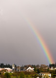 USA, WA, Whidbey Island. Brilliant rainbow after a storm rises from town of Coupeville
