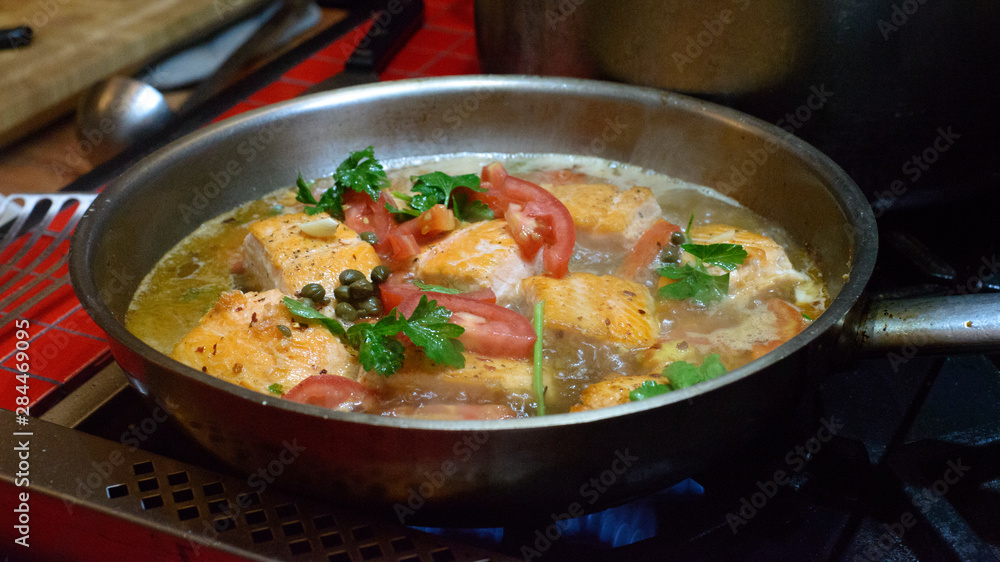 Cooked salmon dish in frying pan.