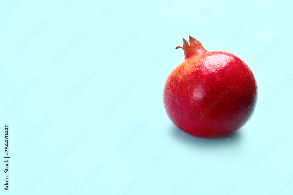 Tasty raw pomegranate on blue background, space for text Tasty raw pomegranate on blue background, space for text
