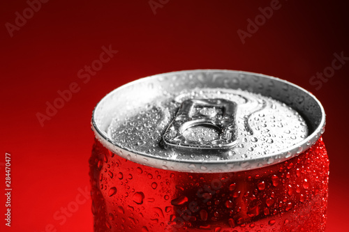Wet closed can on red background, closeup