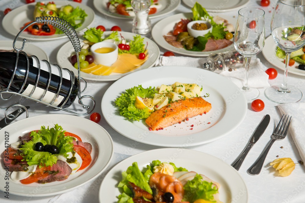 A dish of salmon and boiled potatoes in a plate on the table. Hot restaurant dish. A dish of salmon and boiled potatoes in a plate on the table. Hot restaurant dish.