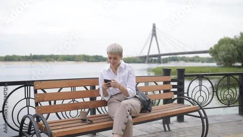 Wallpaper Mural Coffee break. Business woman sitting in the park on a bench, working with a phone Torontodigital.ca