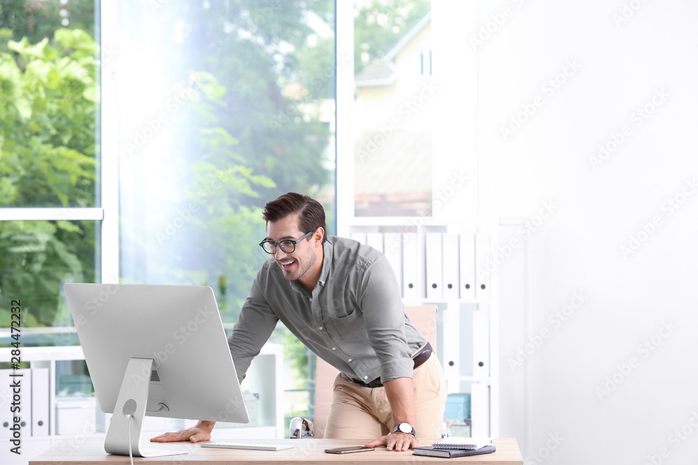 Handsome young man working with computer in office
