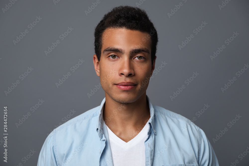 Handsome young African-American man on grey background Handsome young African-American man on grey background